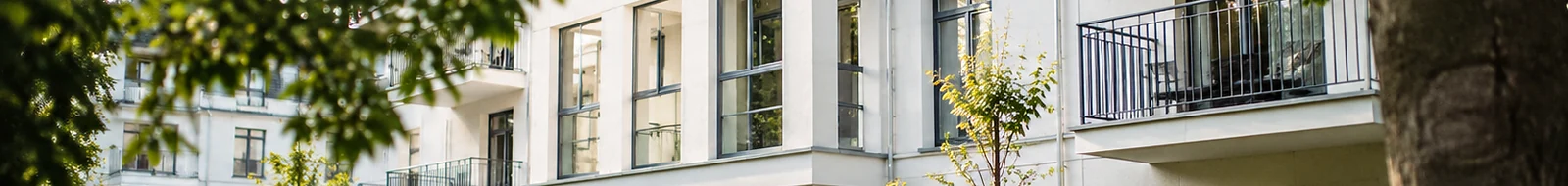 Helle Gebäudearchitektur mit begrüntem Zugang